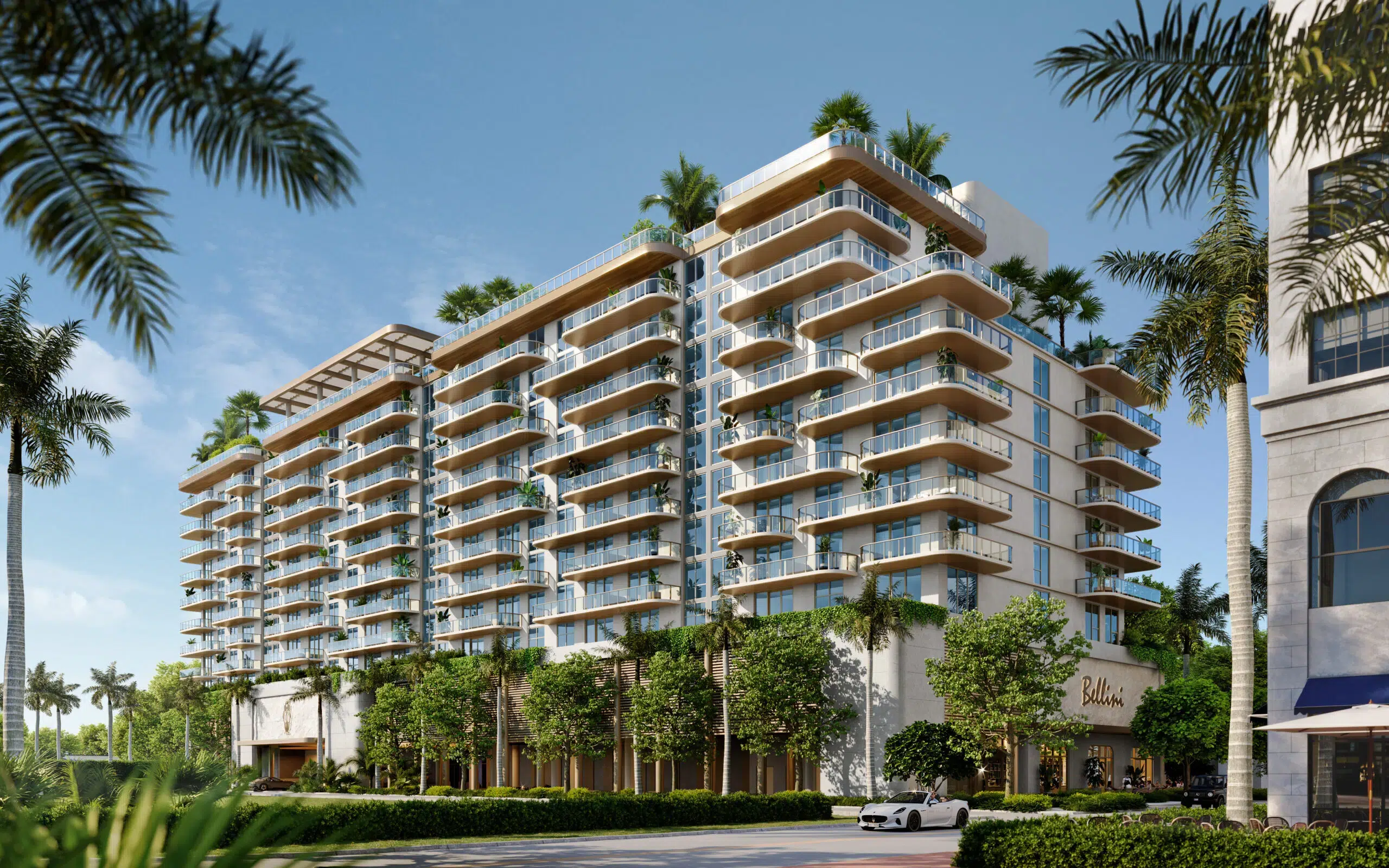 Exterior view of Mr. C Residences showcasing its signature curved glass balconies and lush landscaping.