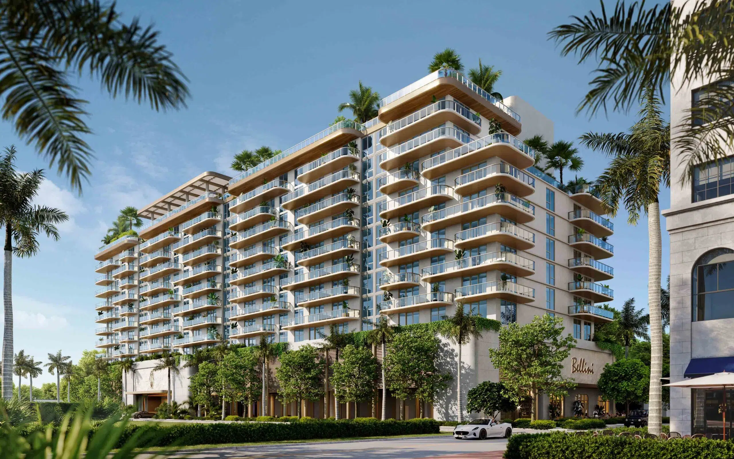 Exterior view of Mr. C Residences showcasing its signature curved glass balconies and lush landscaping.